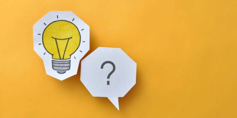Lightbulb and question mark on yellow paper