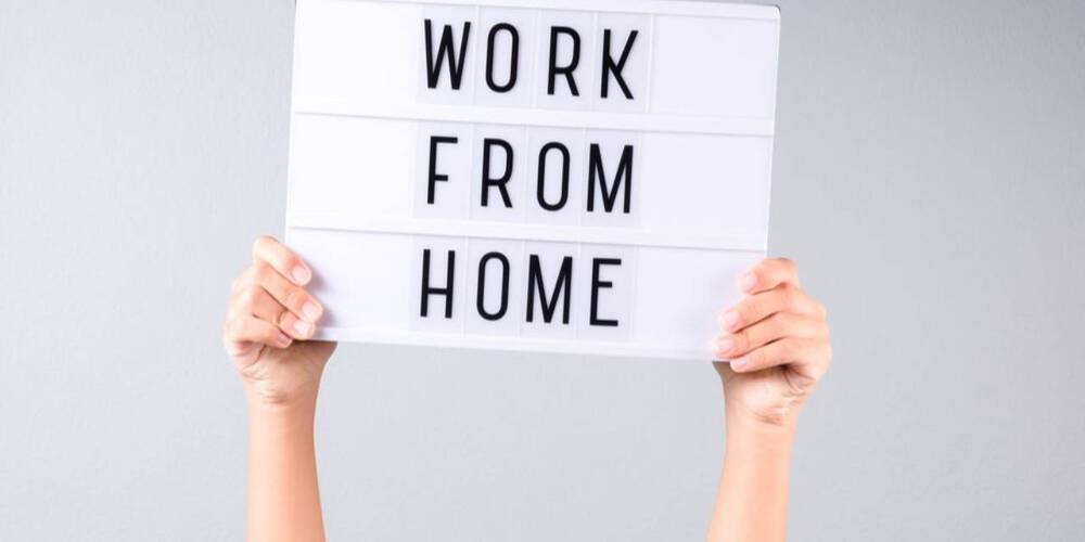 Hands holding sign sating work from home